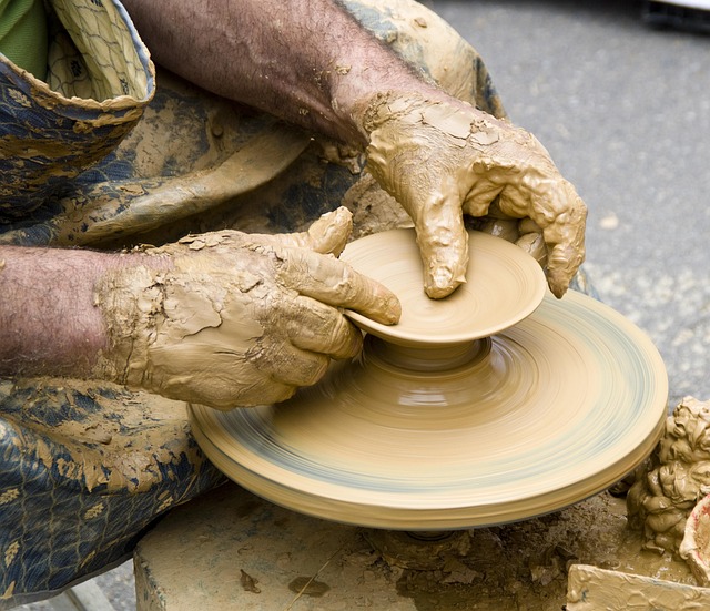 close up of hands wrapping finished wheel of artisan cheese in wax paper for farm shop display